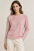 Modella con maglia merino rosa e cuciture raglan sulle spalle